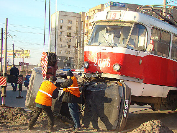 Самара 2009г. Трамвай протащил автомобиль несколько метров до небольшой ямы, опрокинул на правый бок и встал прямо на него Это картинка